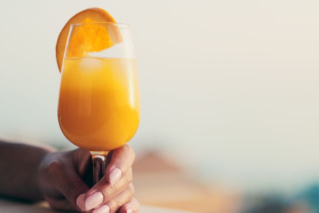 Hand Holding Refreshing Orange Juice Glass with Slice - Download Free Stock Photos Pikwizard.com