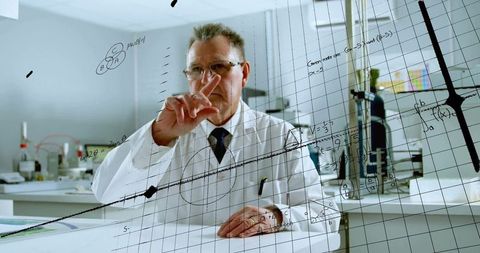 Senior scientist analyzing complex data visualizations on glass panel in modern laboratory