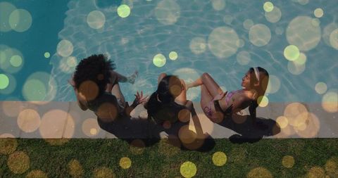 Three friends relaxing poolside with dangling feet and sunlit bokeh summer backyard scene