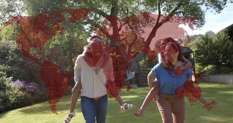 Family walking with children piggyback in sunlit garden with red world map overlay