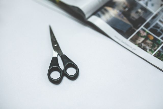 Pair of Scissors on White Surface with Open Magazine - Download Free Stock Photos Pikwizard.com