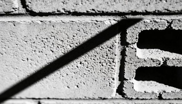 Casting Diagonal Shadow Across Textured Concrete Block Wall