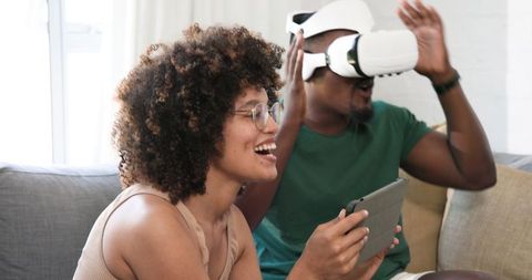 Friends Enjoying Virtual Reality and Tablet Gaming at Home