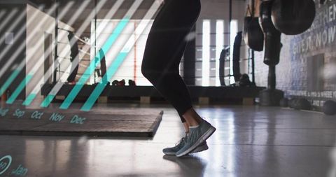 Athlete jumping and landing on studio floor with teal overlay, dynamic fitness action