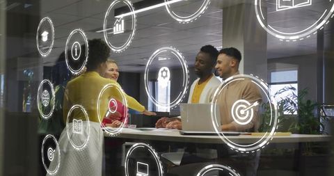 Diverse office team brainstorming around standing table with digital UX icons overlay