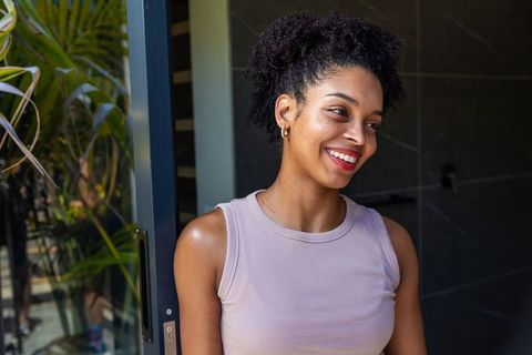 African american woman smiling in doorway wearing mauve tank top natural sunlight portrait