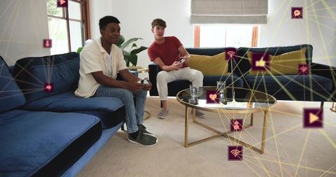 Friends gaming on lounge sofa holding wireless controllers with social network overlay