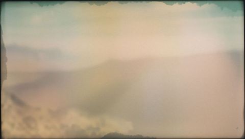 Dreamy pastel dunes melting into haze with vintage film border and grainy vignette