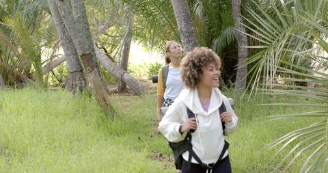 Young Women Hiking in Lush Greenery Enjoying Outdoor Adventure