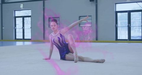 Teen gymnast performing seated floor routine with pink smoke and sparkling leotard