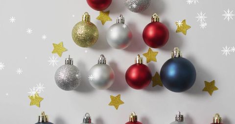 Festive Arrangement of Christmas Baubles and Stars with Falling Snow