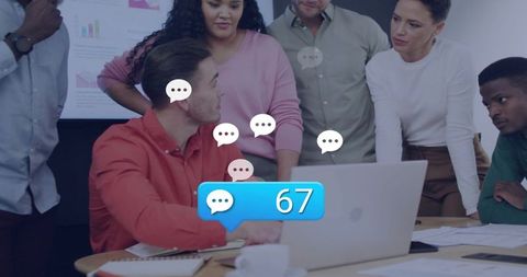 Team collaborating around laptop showing social media chat notifications with 67 comments