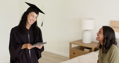 Joyful Graduate in Cap and Gown Sharing Success at Home
