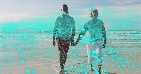Walking couple holding hands on beach with turquoise particle overlay, seaside horizon