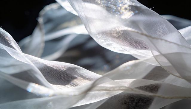 Sheer white chiffon and organza layers drifting backlit with sparkling highlights