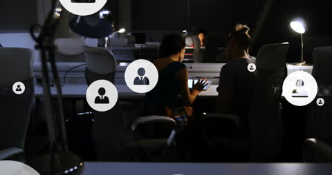 Team Collaborating in Dark Office with Digital Interfaces