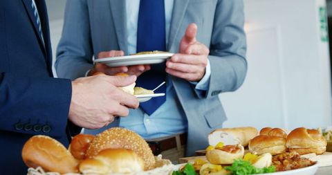 Businessmen Conversing Over Lunch Buffet