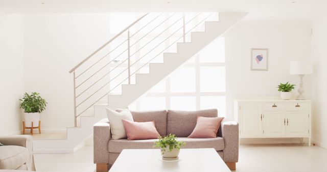 Living room showcasing modern, minimalistic interior design with a staircase, neutral tones, and natural light. Ideal for articles on contemporary home decor, interior design inspiration, or minimalist style rooms.