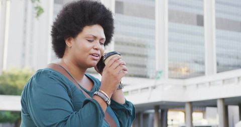 Thoughtful Woman Enjoying Coffee Outdoors in Urban Environment