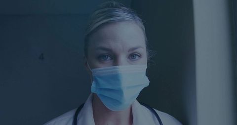 Medical Professional Adjusting Mask in Hospital Hallway