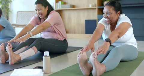 Senior african american women stretching together in yoga class for flexibility and wellness