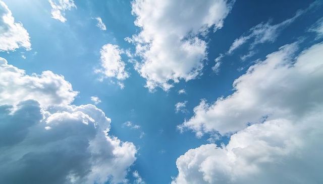 Sunlit Cumulus Cloudscape Framing Expansive Azure Sky with Wispy Cirrus Streaks and Light Rays