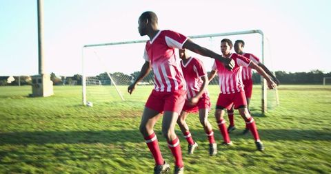 Soccer Team Reacting to Free Kick on Sunny Grass Field