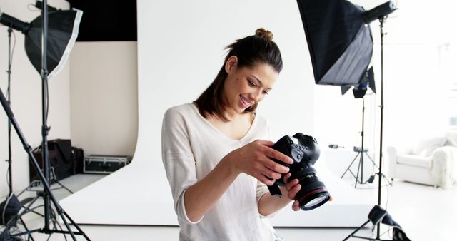 Female Photographer Reviewing Camera Settings in Professional Photo Studio - Download Free Stock Images Pikwizard.com