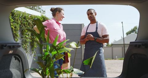 Gardening Enthusiasts in Suburban Yard Discussing Potted Plants