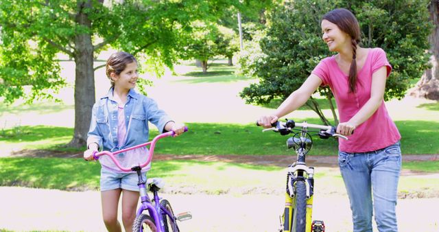 Mother and Daughter Walking Bicycles in Park - Download Free Stock Images Pikwizard.com