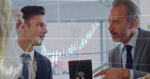 Executives Discussing Market Strategy Pointing at Tablet Showing Candlestick Chart Overlay
