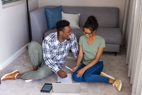 Young diverse couple working on budget and planning new home with laptop and paperwork
