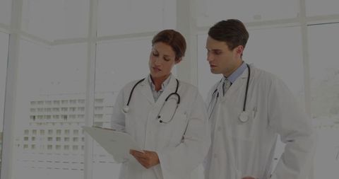 Doctors reviewing patient information in hospital corridor
