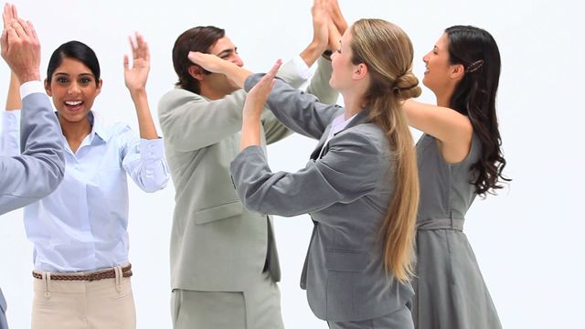 Business professionals from diverse backgrounds celebrating a successful achievement with high fives and applause. Useful for illustrating teamwork, corporate achievement, diversity in the workplace, and positive office dynamics.