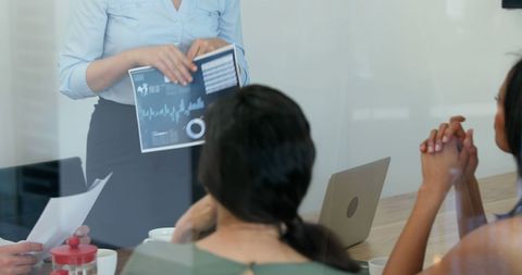 Business Meeting with Report Presentation and Diverse Professionals