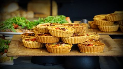 Homemade Savory Quiches with Fresh Ingredients on Wooden Board