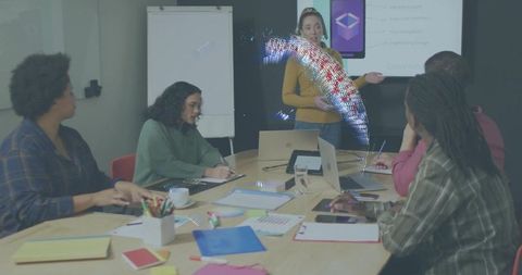 Diverse team collaborating in conference room with presenter showcasing mobile app demo
