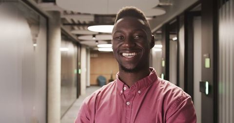 Confident Professional Smiling in a Modern Office Corridor