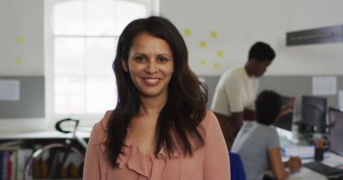 Confident businesswoman smiling in modern collaborative office