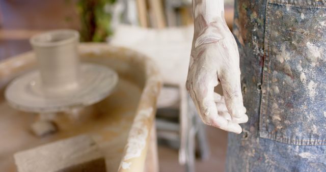 Dirty hand of biracial male potter, standing in pottery studio. Pottery, ceramics, handmade, local business, hobbies and craft, unaltered.
