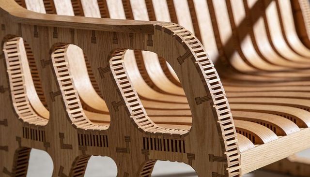 Curved laminated oak slatted bench showing finger-joint detail and laser-cut craftsmanship