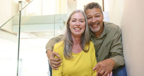 Happy Couple Relaxing in Modern Home Staircase