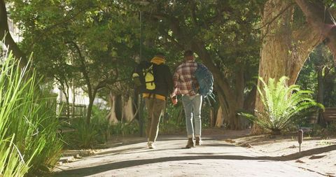 Happy Biracial Gay Couple Walking in Park with Backpacks - Download Free Stock Images Pikwizard.com