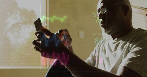 Senior man holding smartphone viewing augmented reality vitals overlay by sunlit window
