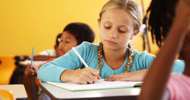 Young Student Writing with Focus in Classroom - Download Free Stock Images Pikwizard.com