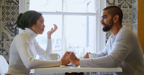 Couple Engaging Over Coffee in Cozy Cafe Atmosphere