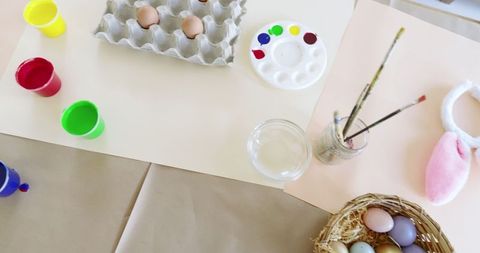 Artistic easter craft table with eggs and painting supplies
