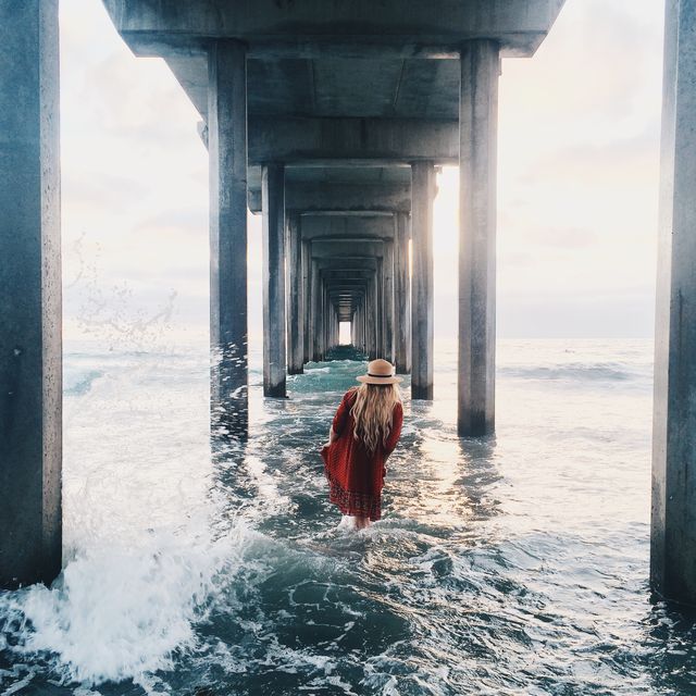 Woman Walking Under a Pier at Sunset - Download Free Stock Images Pikwizard.com