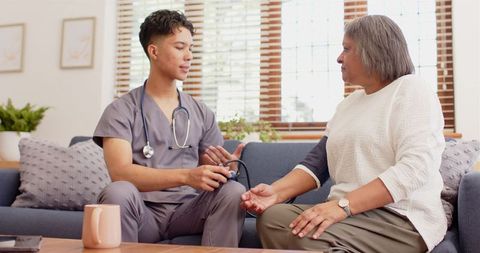 Physiotherapist Consults Senior Woman in Relaxed Home Environment