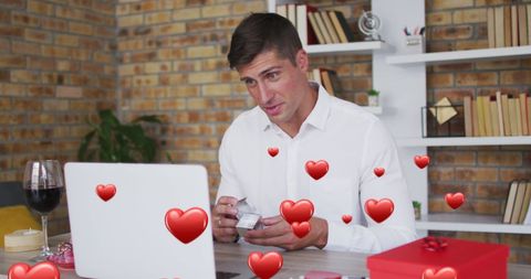 Man proposing via video call surrounded by hearts on display